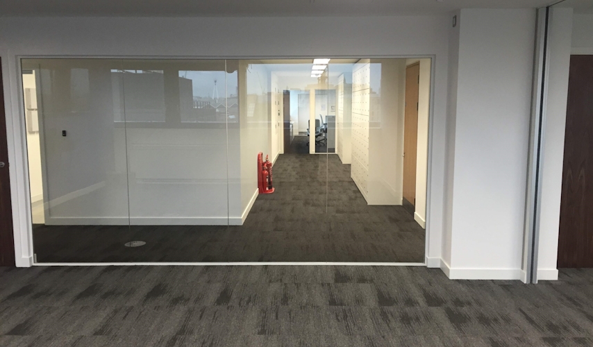 Commercial interior showing a large glass office partition creating a private meeting room.